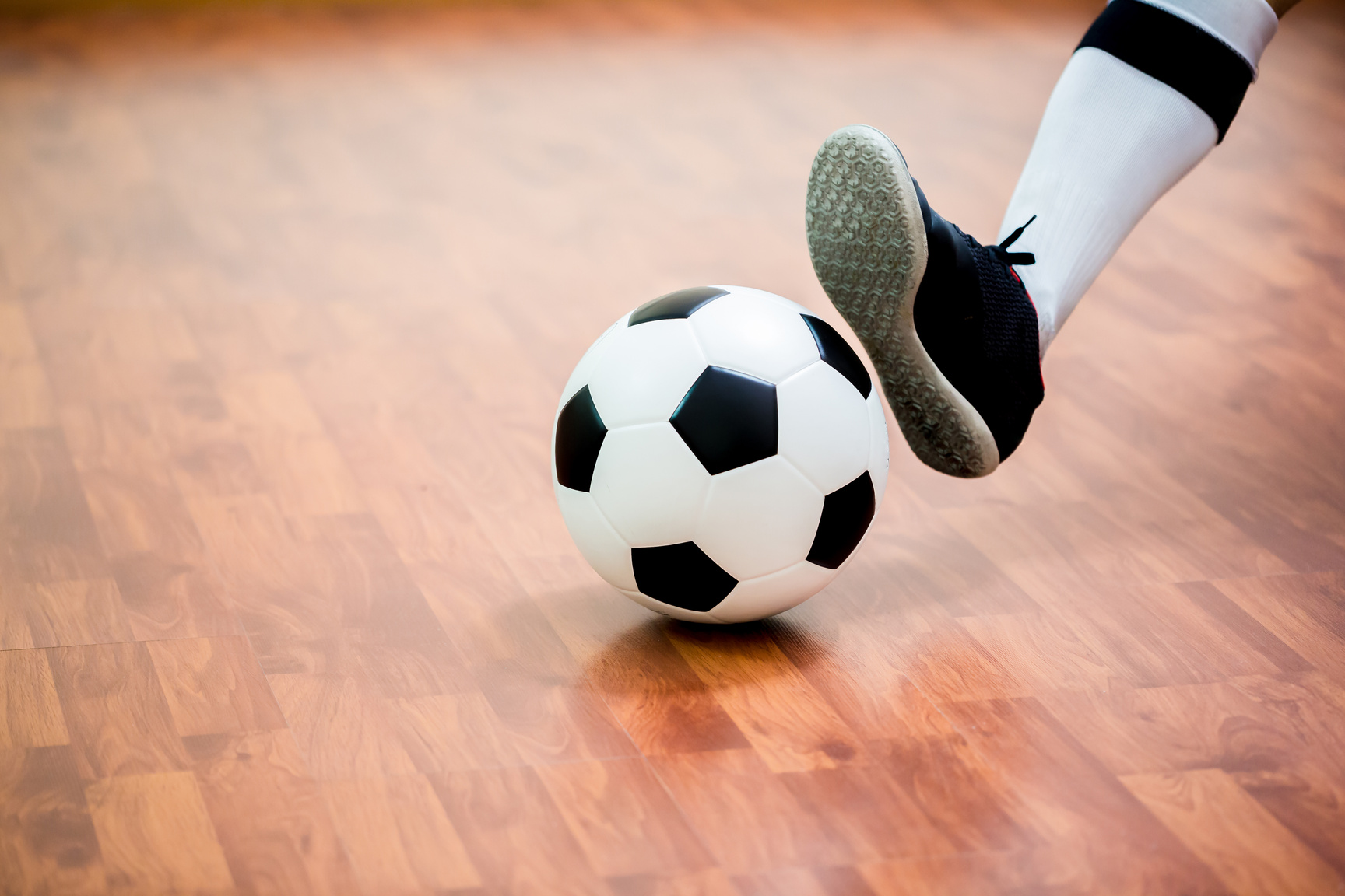 Indoor soccer sports hall. Football futsal player, ball, wooden futsal floor. Sports background.